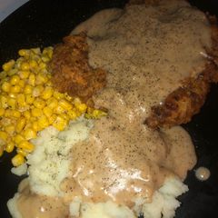 A picture of Country fried steak with beef pepper gravy.