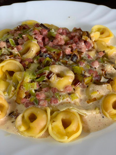 Una foto de Tortellinis de queso con puerro, jamón y salsa