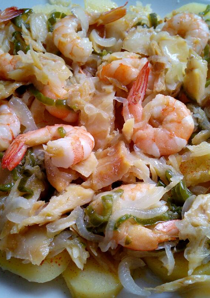 Una foto de Bacalao frito con langostinos, cebollas y pimiento