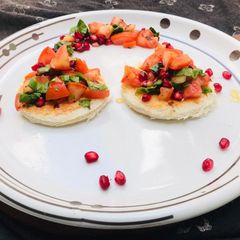 A picture of Tomato Spinach Pomegranate seeds open sandwich.