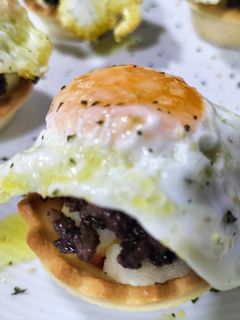 Una foto de Mini-tartaletas de morcilla, manzana y huevo de codorniz