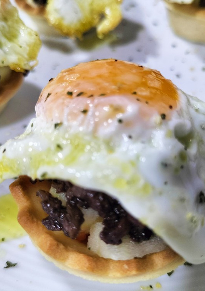Una foto de Mini-tartaletas de morcilla, manzana y huevo de codorniz