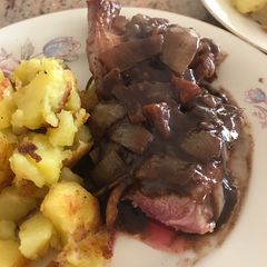 A picture of Lamb steak with red wine and onion sauce.