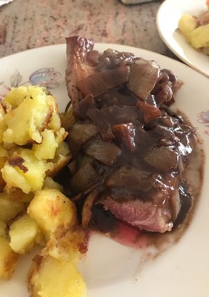 A picture of Lamb steak with red wine and onion sauce.