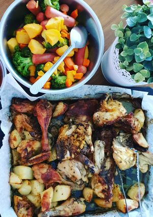 A picture of Roasted chicken with baked potato & sausages.