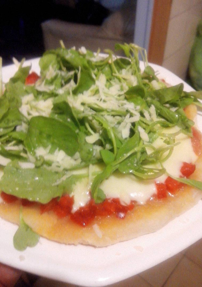 Una foto de Pizza individual con rúcula y parmesano sin horno