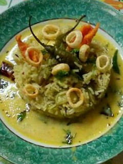 A picture of Mango kadhi with green pulao.