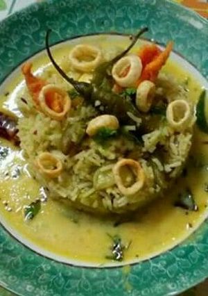 A picture of Mango kadhi with green pulao.