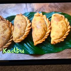 A picture of Kadbu (Sweet Calzones) - 8 Karanji with Puran Stuffing.