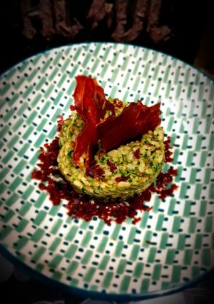 Une photo de Risotto au prosecco, crème de roquette et chips de speck
