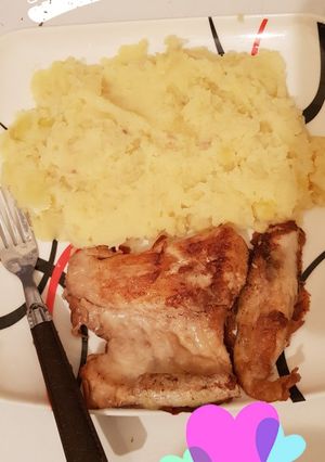 A picture of Mashed potatoes and fish fillet.