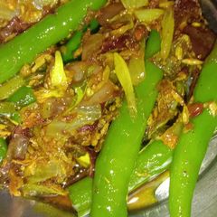 A picture of Green chillies with onion masala.