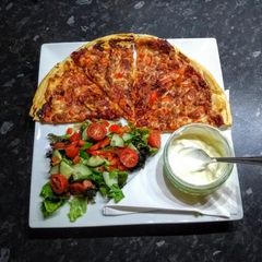 A picture of Home made pizza with garlic dip.