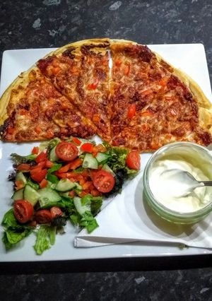 A picture of Home made pizza with garlic dip.