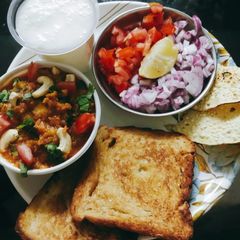 A picture of Pavbhaji with buttermilk papad and salad.