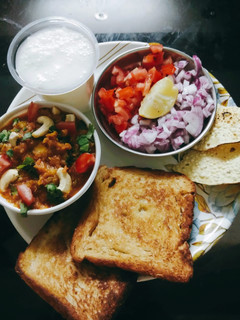 A picture of Pavbhaji with buttermilk papad and salad.