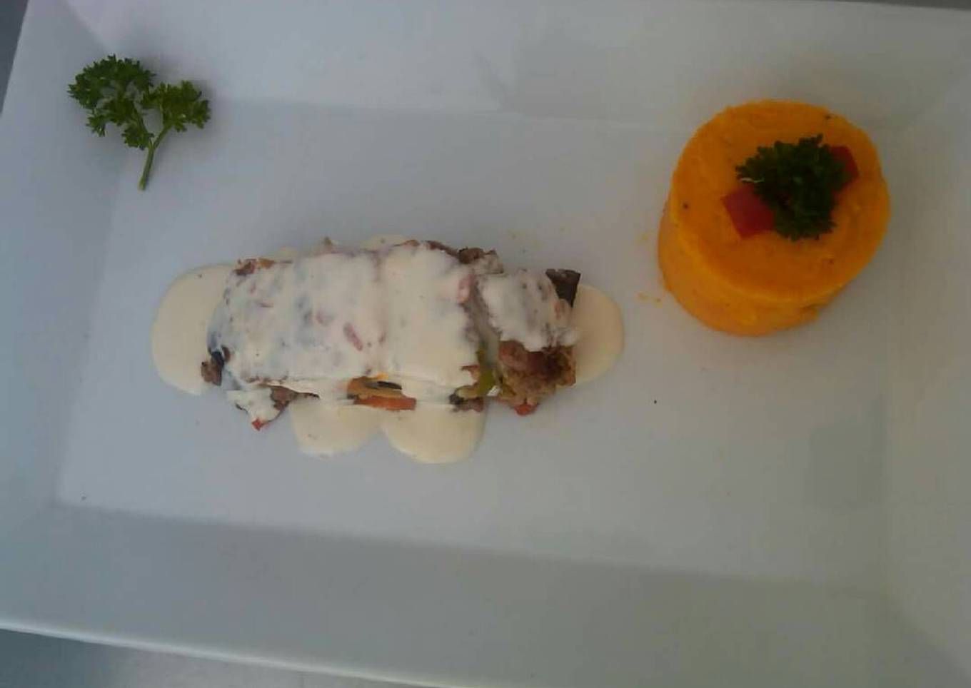 Terrina de carne rellena de vegetales y queso en salsa gorgonzola.