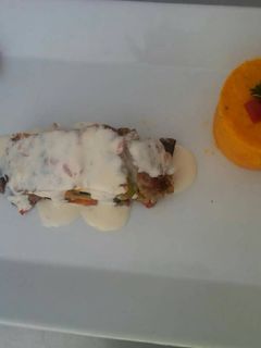Una foto de Terrina de carne rellena de vegetales y queso en salsa gorgonzola.