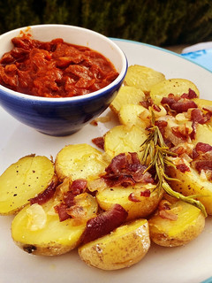 Una foto de Calamares en salsa americana con patatas aromatizadas al romero y mandarina con cebolla pochada