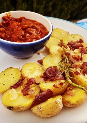 Una foto de Calamares en salsa americana con patatas aromatizadas al romero y mandarina con cebolla pochada