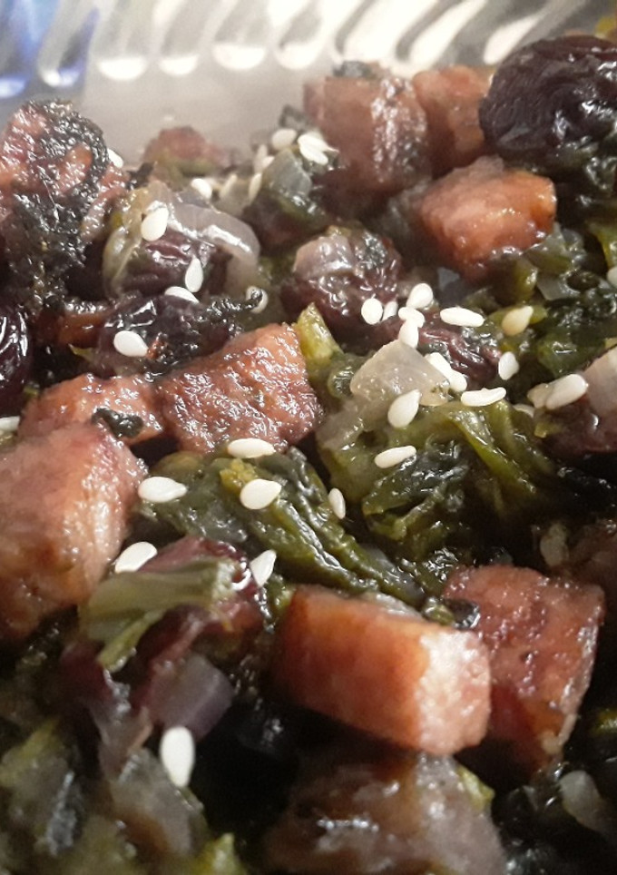 Una foto de Espinacas con uvas pasas y jamón de cerdo...🌿🌰🍖🥓🍇
