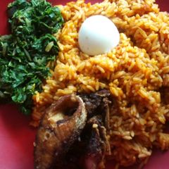 A picture of Jollof rice with fried crocker fish and vegetable.