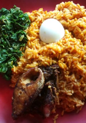 A picture of Jollof rice with fried crocker fish and vegetable.