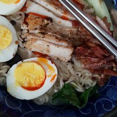 A picture of Kontaksu (pork) Ramen with eggs hot chili oil and spinach.