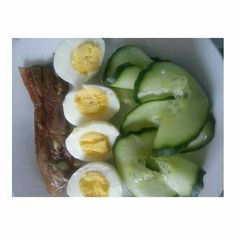 A picture of Grilled fish, cucumber and boiled egg.