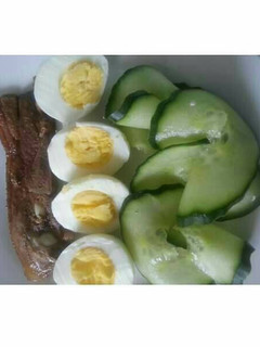 A picture of Grilled fish, cucumber and boiled egg.