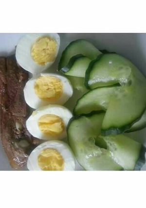 A picture of Grilled fish, cucumber and boiled egg.