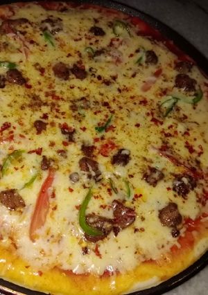A picture of Chicken tikka pizza without Oven.
