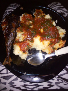 A picture of Mashed potatoes,tomato stew and deep fried fish...
