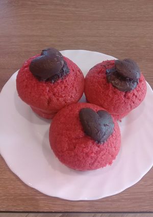A picture of Vanilla coloured cupcakes with a touch of heart chocolate on top.