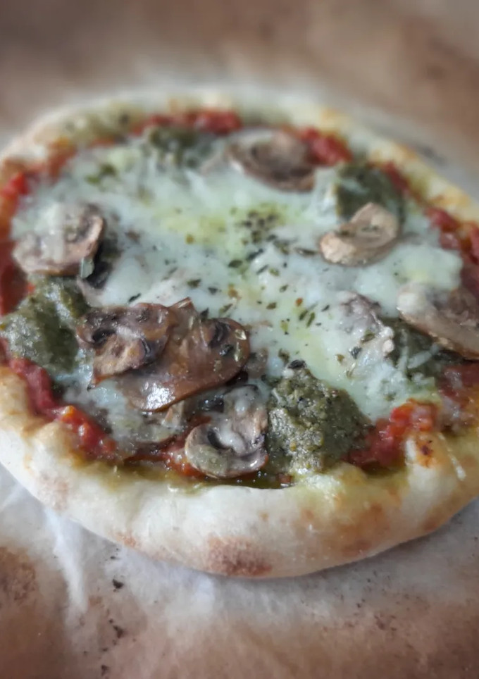 Una foto de Pizza de pesto y champiñones