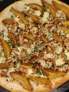 Una foto de Flammkuchen de queso azul, peras, y nuez, con masa pascualina