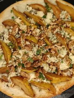 Una foto de Flammkuchen de queso azul, peras, y nuez, con masa pascualina