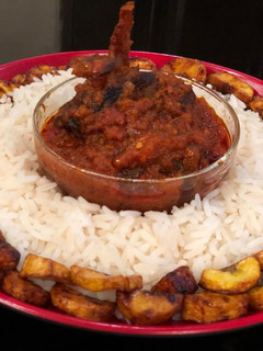A picture of Rice, assorted stew and plantain.