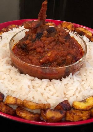 A picture of Rice, assorted stew and plantain.