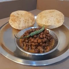 A picture of Kala chana sabji with puri.
