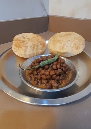 A picture of Kala chana sabji with puri.
