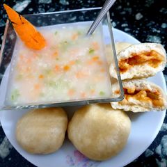 A picture of Rice soup with stuffed bun.