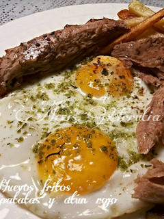 Una foto de Huevos fritos con ajos, perejil y troncos de atún rojo