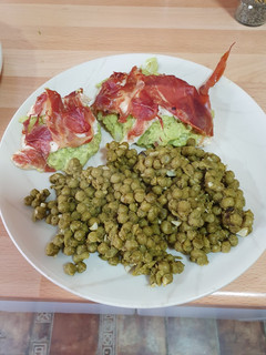 Una foto de Pechuga de pollo con guacamole acompañado de guisantes