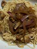 Fideos en salsa blanca acompañados de bistec con champiñones salteados