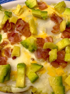 Una foto de Papas a la Guti con tocino y aguacate