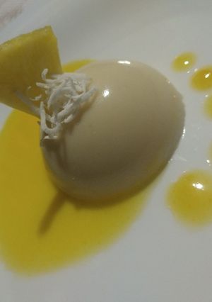 Una foto de Panna cotta de coco Coulis de piña