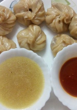 A picture of Chicken momo with soup and chutney.