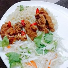 A picture of Rice with fried chicken and vegetables.