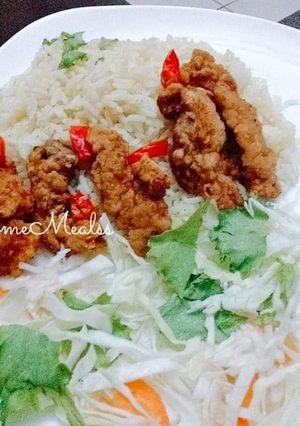 A picture of Rice with fried chicken and vegetables.